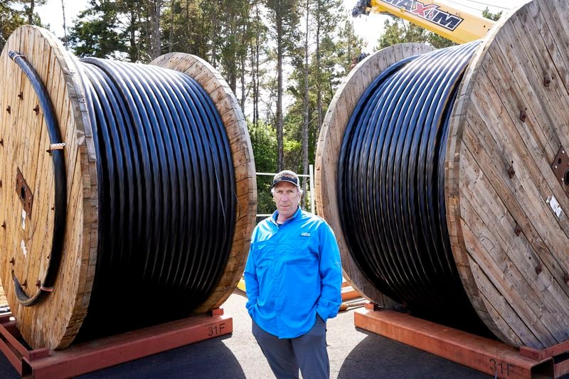 Burke Hales, chief scientist for the PacWave wave energy test site overseen by Oregon State University, stands in front of the electric cables that are buried under the seabed in Newport, Ore., Friday, Aug. 23, 2024. (AP Photo/Craig Mitchelldyer)