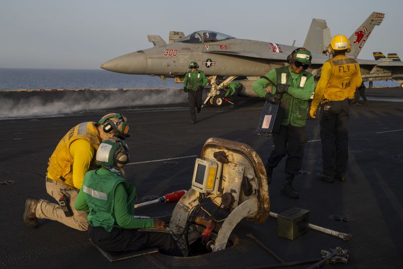 Crew members work during take off operations on the deck of the USS Dwight D. Eisenhower in the Red Sea on Tuesday, June 11, 2024. (AP Photo/Bernat Armangue)