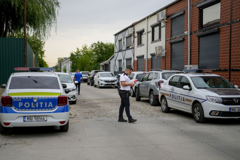 A police officer stands outside the residence of internet influencer Andrew Tate during an early morning police search raid, on the outskirts of Bucharest, Romania, Wednesday, Aug. 21, 2024. (AP Photo/ Vadim Ghirda)