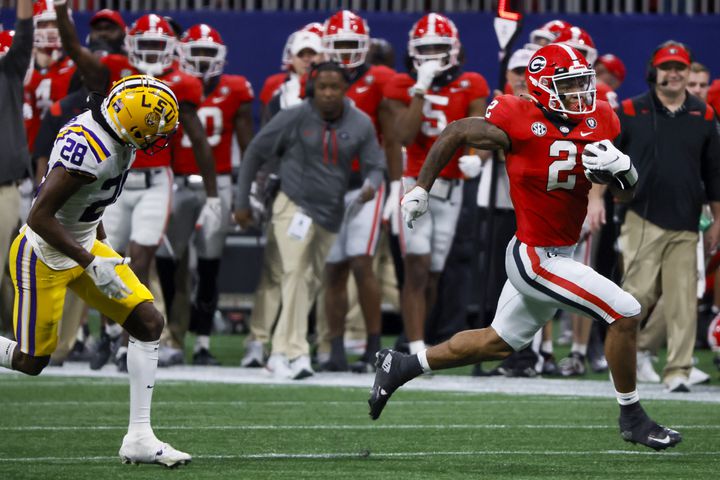 Georgia Bulldogs running back Kendall Milton (2) runs past LSU Tigers safety Major Burns (28) during the second half of the SEC Championship Game at Mercedes-Benz Stadium in Atlanta on Saturday, Dec. 3, 2022. (Bob Andres / Bob Andres for the Atlanta Constitution)