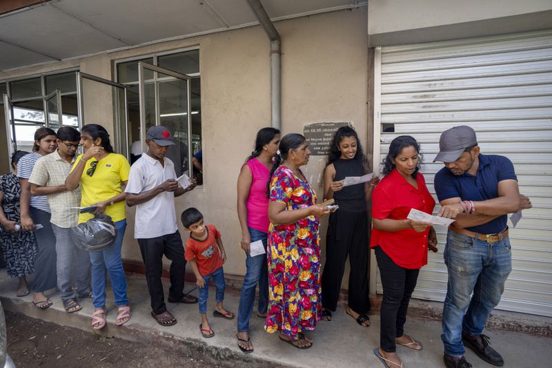 People wait in a queue to cast their votes at a polling center during the presidential election Colombo , Sri Lanka Saturday, Sept. 21, 2024.(AP Photo/Rajesh Kumar Singh)