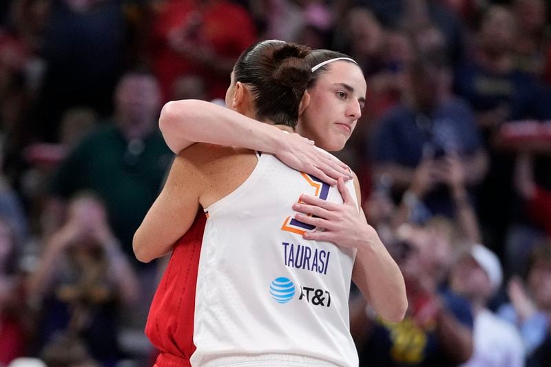 Indiana Fever guard Caitlin Clark hugs Phoenix Mercury's Diana Taurasi (3) before the first half of a WNBA basketball game, Friday, Aug. 16, 2024, in Indianapolis. (AP Photo/Darron Cummings)