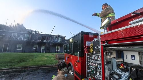 East Point firefighters work to put out hot spots at what is left of a building at The Park at Galaway Apartments on Thursday morning. A large fire destroyed several units Wednesday afternoon.