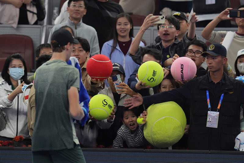 Jannick Sinner of Italy autographs for fans after defeating Roman Safiullin of Russia during the China Open tennis tournament held at the National Tennis Center in Beijing, Saturday, Sept. 28, 2024. (AP Photo/Ng Han Guan)