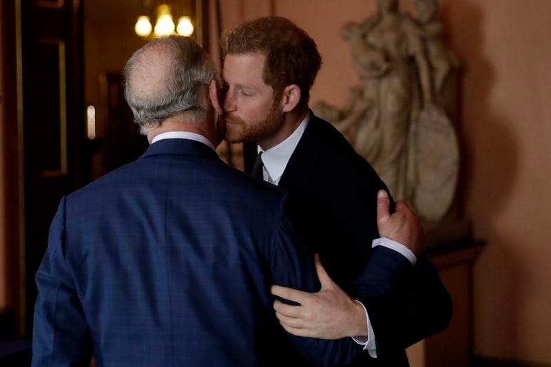 Britain's Prince Harry kisses and greets his father Prince Charles upon their separate arrival to attend a coral reef health and resilience meeting with speeches and a reception with delegates at Fishmongers Hall in London, Wednesday, Feb. 14, 2018. (AP Photo/Matt Dunham, Pool, File)