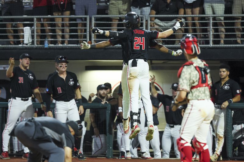 Georgia third baseman Charlie Condon (24) celebrates his solo home run with a teammate during the ninth inning against N.C. State in Game 3 of the NCAA Super Regional at Foley Field, Monday, June 10, 2024, in Athens, Ga. This was Condon’s 37th home run of the season. Georgia lost 8-5. (Jason Getz / AJC) 