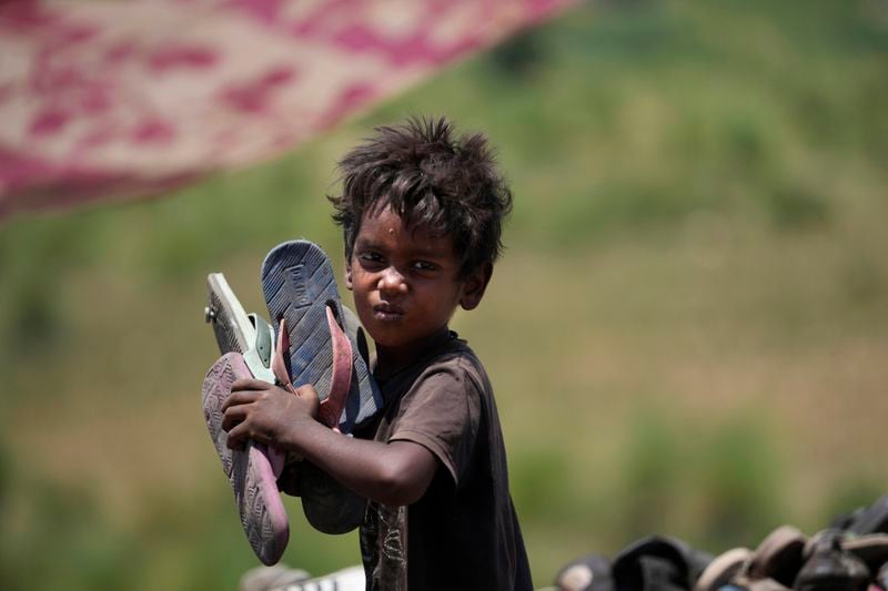 Waste picker Arjun, 6, works at garbage dump site during a heat wave on the outskirts of Jammu, India, on June 20, 2024. As many as 4 million people in India scratch out a living searching through landfills for anything they can sell. (AP Photo/Channi Anand)