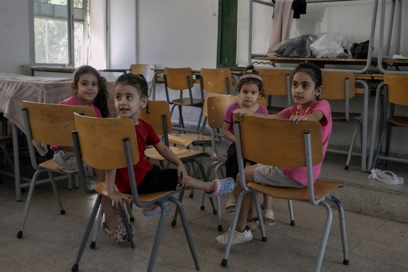 Displaced children sit in a classroom in Beirut, after fleeing the Israeli airstrikes in the south with their families, Thursday, Sept. 26, 2024. (AP Photo/Bilal Hussein)