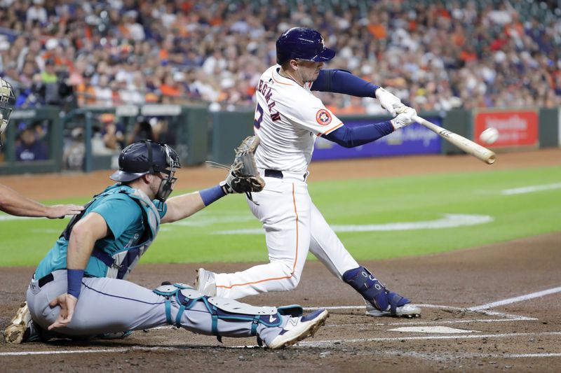 Houston Astros' Alex Bregman (2) connects for a home run in front of Seattle Mariners catcher Cal Raleigh, left, during the first inning of a baseball game Tuesday, Sept. 24, 2024, in Houston. (AP Photo/Michael Wyke)