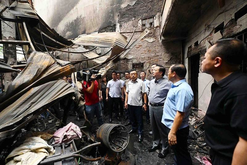 Officials visit the site of a house fire in Hanoi, Vietnam Friday, May 24, 2024. Authorities said the fire has killed a number of people and injured a few others. (Bui Van Lanh/VNA via AP)