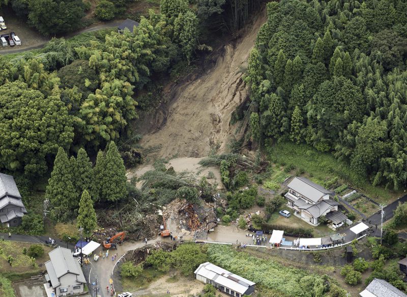 This aerial image shows the landslide in Gamagori, Aichi prefecture, Japan, Wednesday, Aug. 28, 2024. Ahead of the typhoon's arrival, heavy rain caused a landslide that buried a house in the central city of Gamagori. (Kyodo News via AP)