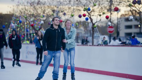 Anthony Keith (left) holds hands with Hannah Shuler as they ice skate at Atlantic Station in Atlanta during the annual Christmas tree lighting as thousands of people watch the show on Nov. 23, 2013.