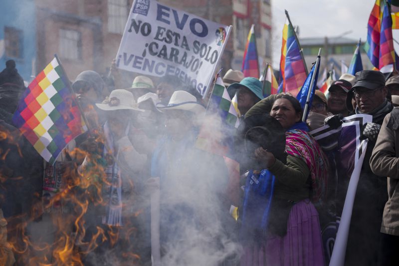 Demonstrators give an offering to Mother Earth before marching to the capital, led by former President Evo Morales, as part of a political dispute with current President Luis Arce and to protest his handling of the economy in Caracollo, Oruro, Bolivia, Tuesday, Sept. 17, 2024. (AP Photo/Juan Karita)