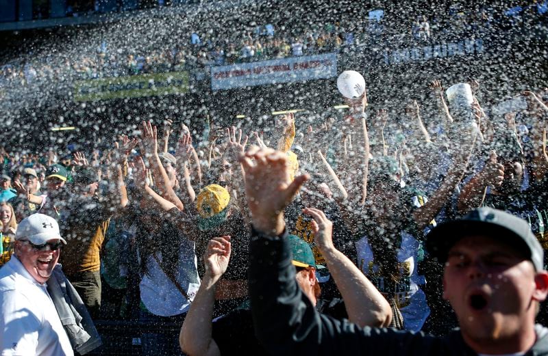 FILE - Oakland Athletics fans celebrate after the Athletics defeated the Minnesota Twins in a baseball game to become American League West champions, Sept. 22, 2013, in Oakland, Calif. (AP Photo/Beck Diefenbach, File)