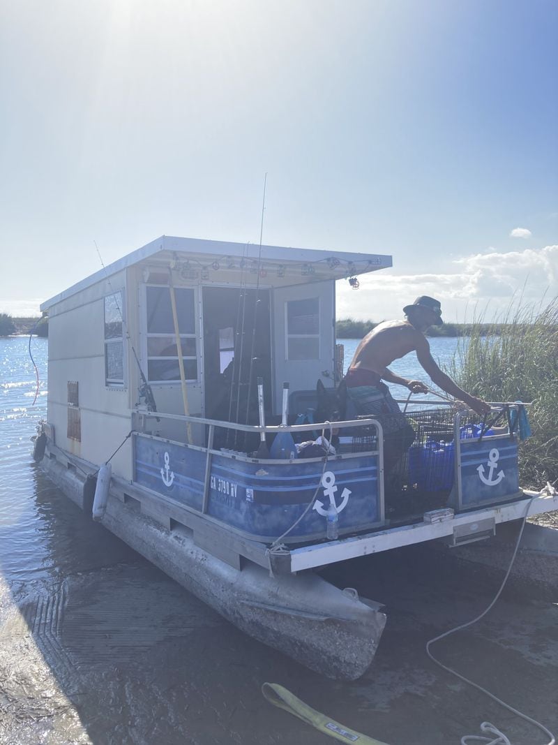 A boater who identifies himself only by the name Huck returns to his vessel, Castaway, on Wednesday after a small group of Savannah residents helped remove it from along U.S. 80 near Tybee Island. Huck's boat was set adrift during Hurricane Helene and floated onto the shoulder of the causeway. (Adam Van Brimmer/AJC)