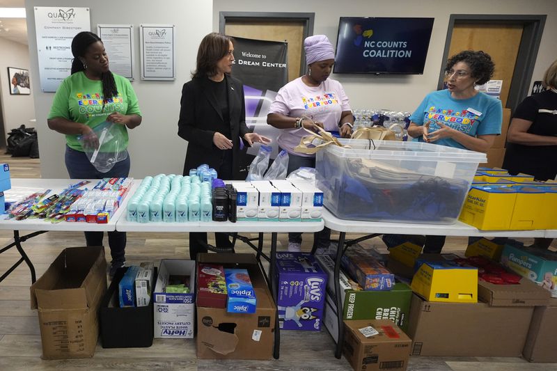 Democratic presidential nominee Vice President Kamala Harris, second left, greets workers at a food drop-off and distribution center after receiving a briefing on the damage from Hurricane Helene, Saturday, October 5, 2024, in Charlotte, N.C. (AP Photo/Chris Carlson)