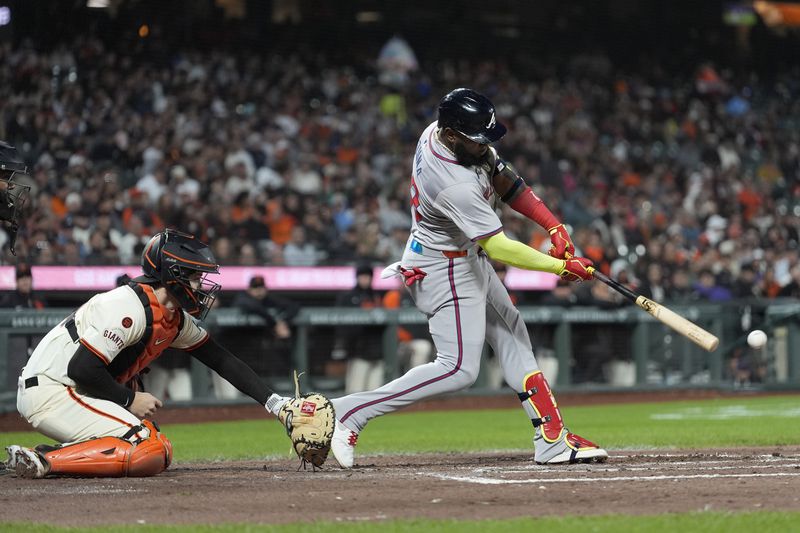 Atlanta Braves' Marcell Ozuna, right, hits a double in front of San Francisco Giants catcher Patrick Bailey during the seventh inning of a baseball game in San Francisco, Monday, Aug. 12, 2024. (AP Photo/Jeff Chiu)