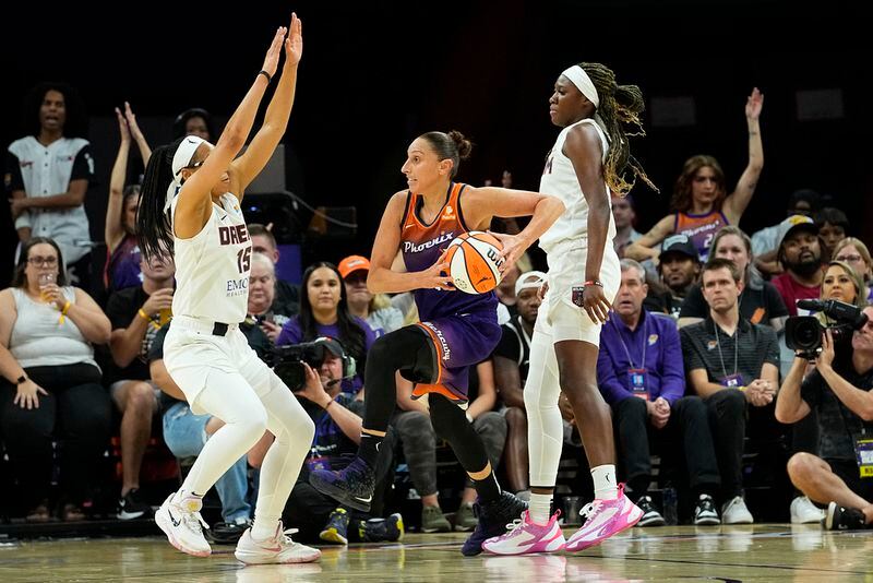 Phoenix Mercury guard Diana Taurasi, center, drives as Atlanta Dream Allisha Gray (15) defends during the first half of a WNBA basketball game, Thursday, Aug. 3, 2023, in Phoenix. (AP Photo/Matt York)