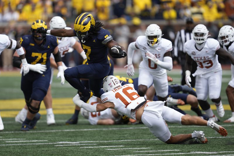 Michigan running back Donovan Edwards (7) is brought down by Texas defensive back Michael Taaffe (16) in the first half of an NCAA college football game in Ann Arbor, Mich., Saturday, Sept. 7, 2024. (AP Photo/Paul Sancya)