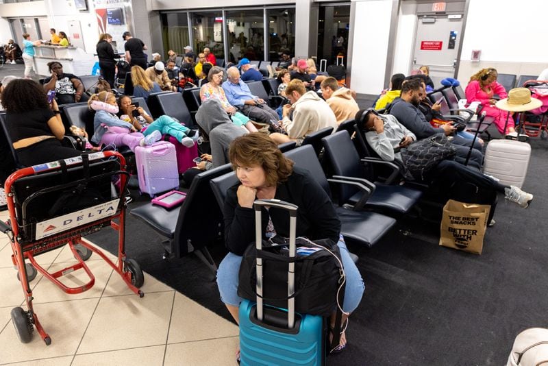 Travelers wait at a gate at Hartsfield-Jackson International Airport late in the evening in Atlanta on Saturday, July 20, 2024, following a global technology outage that has hampered airlines and other industries. (Arvin Temkar / AJC)