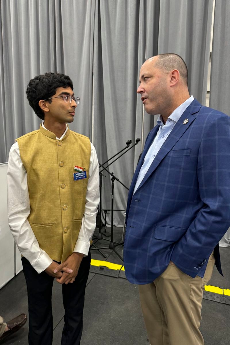 Democratic candidate Ashwin Ramaswami, left, greets Republican Georgia Attorney General Chris Carr at the Festival of India in Duluth, Ga., Aug. 17, 2024. (AP Photo/Charlotte Kramon)