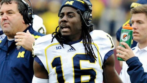 FILE - Michigan head coach Brady Hoke, left, and quarterback Denard Robinson, right, call over the offense during a timeout in the third quarter of an NCAA college football game against Minnesota, Saturday, Nov. 3, 2012, in Minneapolis. (AP Photo/Tom Olmscheid)