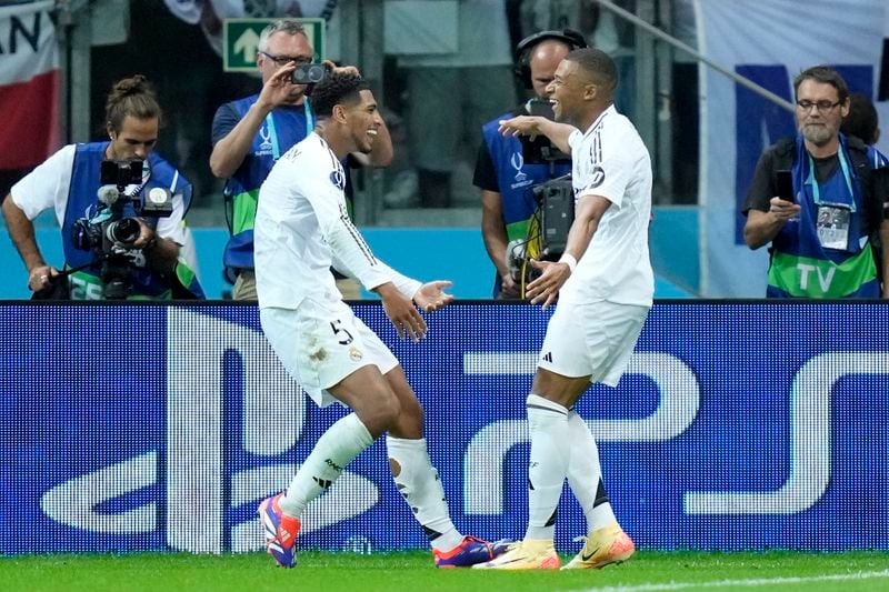 Real Madrid's Kylian Mbappe celebrates with Jude Bellingham, left, after scoring his side's second goal during the UEFA Super Cup Final soccer match between Real Madrid and Atalanta at the Narodowy stadium in Warsaw, Poland, Wednesday, Aug. 14, 2024. (AP Photo/Darko Bandic)