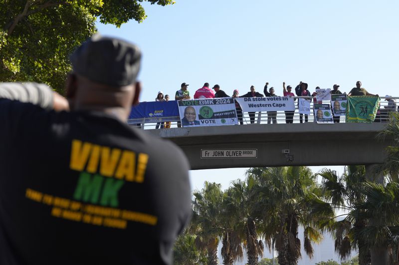 Demonstrators stage a protest along a bridge, in Cape Town South Africa, Friday June 14, 2024. For the first time in 30 years, South African lawmakers will elect a president with the outcome not a mere formality as unprecedented coalition talks between parties continued until right before a new Parliament convened on Friday. (AP Photo/Nardus Engelbrecht)