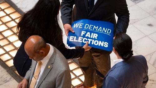 Organizers distribute signs at the Capitol in Atlanta on Monday, Aug. 26, 2024, before a press conference calling for the governor to remove three members of the State Election Board. (Ben Gray / Ben@BenGray.com)