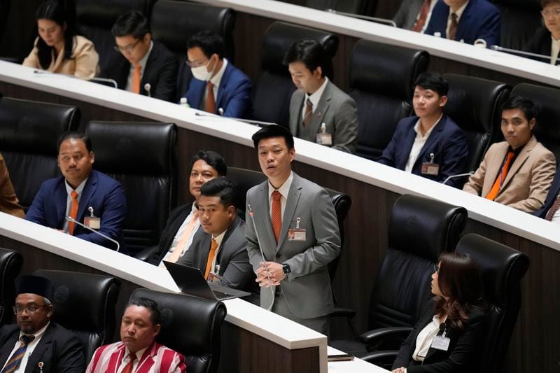 Leader of the People's Party, Natthaphong Ruengpanyawut, standing, debates before a vote to select a new prime minister at the Parliament in Bangkok, Thailand, Friday, Aug. 16, 2024. (AP Photo/Sakchai Lalit)