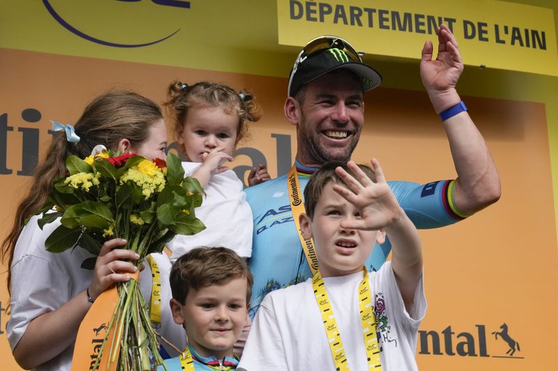 Britain's sprinter Mark Cavendish celebrates on the podium with his wife and children after winning a record 35th Tour de France stage to break the record of Belgian legend Eddy Merckx in the fifth stage of the Tour de France cycling race over 177.4 kilometers (110.2 miles) with start in Saint-Jean-de-Maurienne and finish in Saint-Vulbas, France, Wednesday, July 3, 2024. (AP Photo/Jerome Delay)