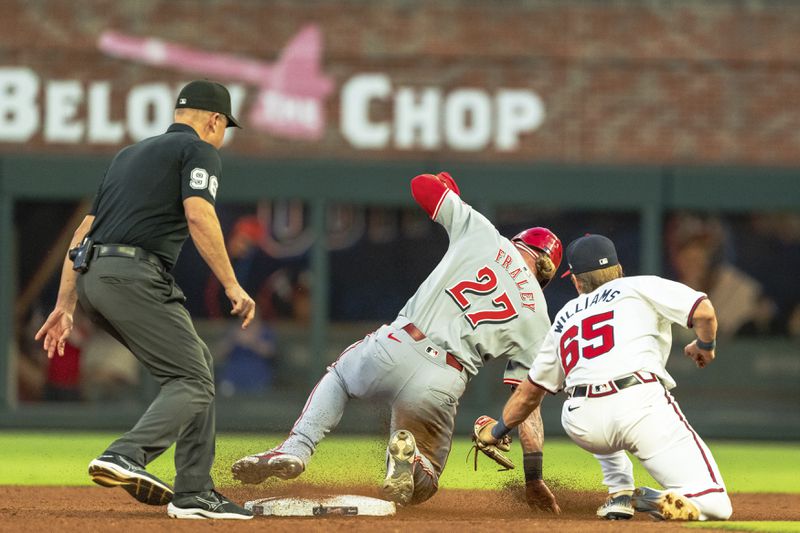 Cincinnati Reds' Jake Fraley (27) successfully steals second base before Atlanta Braves second baseman Luke Williams (65) can tag him in the fourth inning of a make-up baseball game, Monday, Sept. 9, 2024, in Atlanta. (AP Photo/Jason Allen)