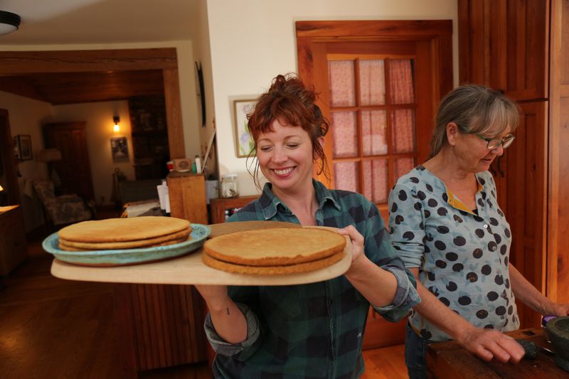 Pastry chef Ashley Capps (left) transfers newly baked cakes from the oven to cool. Capps had gathered with fellow Asheville culinarians Barbara Swell (pictured), Ashley English and Susannah Gebhart to make an apple stack cake, a traditional Appalachian dessert. TYSON HORNE / TYSON.HORNE@AJC.COM