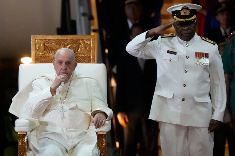 Pope Francis, left, is welcomed by rear-Admiral Philip Polewara as he arrives at Port Moresby's "Jackson" International Airport, Friday, Sept. 6, 2024. As a second leg of his 11-day trip to Asia and Oceania Pope Francis's visit to Papua New Guinea will take him to a remote part of the South Pacific island nation where Christianity is a recent addition to traditional spiritual beliefs developed over millennia.(AP Photo/Gregorio Borgia)