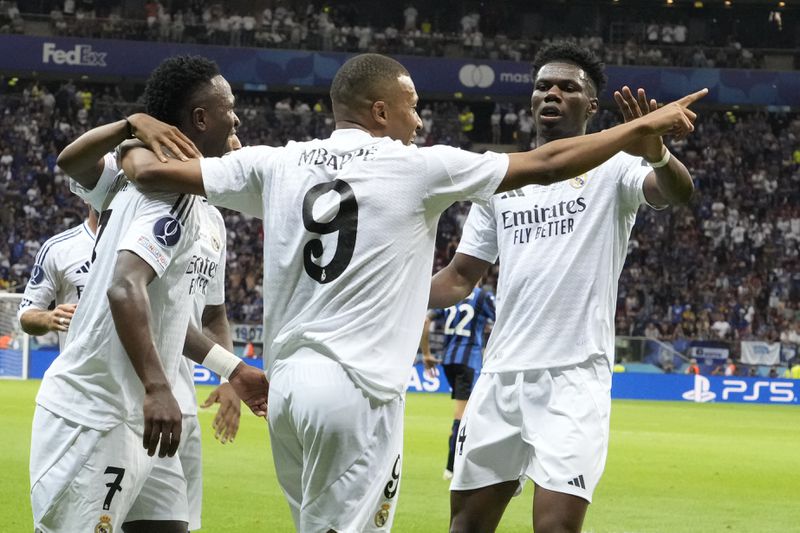 Real Madrid's Kylian Mbappe, centre, celebrates with teammates after scoring his side's second goal during the UEFA Super Cup Final soccer match between Real Madrid and Atalanta at the Narodowy stadium in Warsaw, Poland, Wednesday, Aug. 14, 2024. (AP Photo/Czarek Sokolowski)