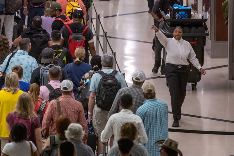 Customer service’s Tihaydra Lacy guides travelers as they move through Hartsfield-Jackson International in Atlanta where peak holiday period passenger counts were expected for Fourth of July trips, with Friday, June 28, 2024 as the peak day. On Friday, TSA expected to screen a record-setting total of more than 3 million people at airport security checkpoints across the country. (John Spink/AJC)