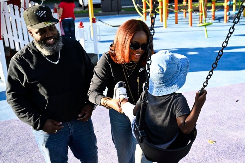 Reggie Cunningham, left, and his wife Ferguson activist Brittany Packnett-Cunningham, center, plays with their son MVP at a playground, Saturday, Sep. 7, 2024, in Mount Rainier, Md. (AP Photo/Terrance Williams)