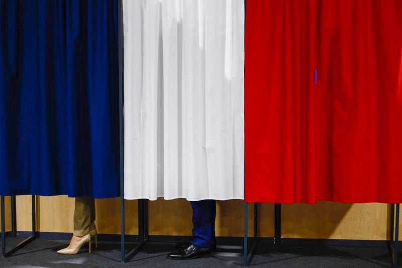 French President Emmanuel Macron and his wife Brigitte Macron stand in the voting booth before voting in Le Touquet-Paris-Plage, northern France, Sunday, June 30, 2024. France is holding the first round of an early parliamentary election that could bring the country's first far-right government since Nazi occupation during World War II. The second round is on July 7, and the outcome of the vote remains highly uncertain (Yara Nardi, Pool via AP)