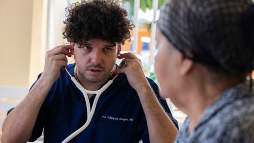 Dr. Pedro Juan Vázquez, better known by his stage name PJ Sin Suela, attends to a patient in Loiza, Puerto Rico, Saturday, May 25, 2024. The 34-year-old doctor travels from the San Juan capital to the island’s southern and central regions to treat communities struggling in the aftermath of hurricanes. After hanging up his doctor’s scrubs, Vázquez spends his time producing new music that relays the island’s issues. (AP Photo/Alejandro Granadillo)