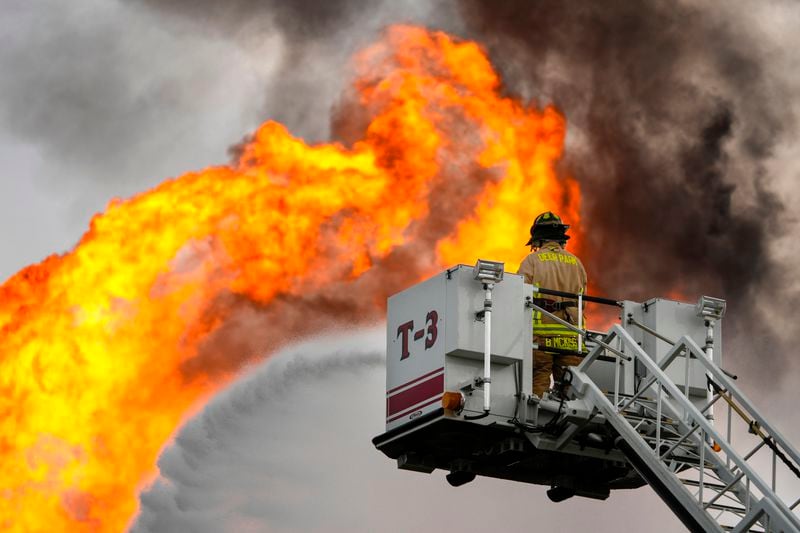 A firefighter directs a line of water around a fire on a pipeline carrying liquified natural gas near Spencer Highway and Summerton on Monday, Sept. 16, 2024, in La Porte, Texas. (Brett Coomer/Houston Chronicle via AP)