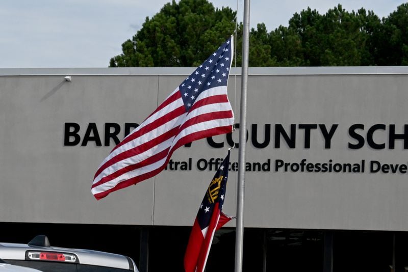 The American and Georgia flags outside Barrow County School System’s central office fly at half-staff a day after two students and two teachers were killed.