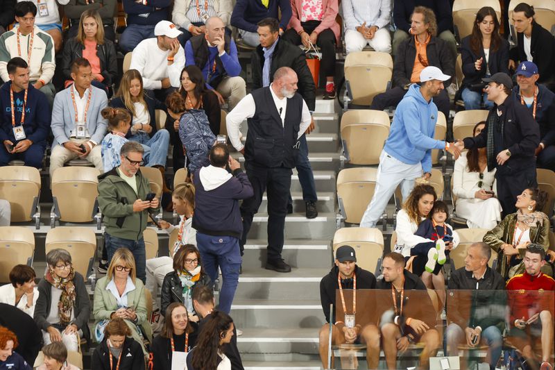 Poland's Iga Swiatek, bottom row fourth from left, Spain's Carlos Alcaraz, top row third from left, and Serbia's Novak Djokovic, standing right in blue sweater and white cap, all watched Spain's Rafael Nadal's first round match of the French Open tennis tournament against Germany's Alexander Zverev at the Roland Garros stadium in Paris, Monday, May 27, 2024. (AP Photo/Jean-Francois Badias)