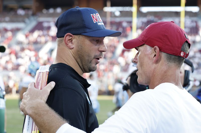 Tulane head coach Jon Sumrall and Oklahoma head coach Brent Venables meet mid field after their NCAA college football game Saturday, Sept. 14, 2024, in Norman, Okla. (AP Photo/Alonzo Adams)