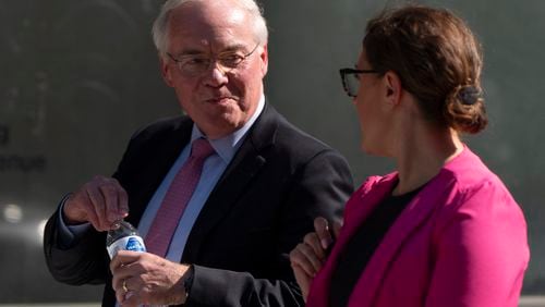 Kroger CEO Rodney McMullen holds a Fred Meyer brand water bottle as he talks with Erin Rolfes, Director of Corporate Communications & Media Relations at Kroger, right, while leaving federal court after testifying during a federal court hearing on Wednesday, Sept. 4, 2024, in Portland, Ore. Fred Meyer's parent company is Kroger. (AP Photo/Jenny Kane)