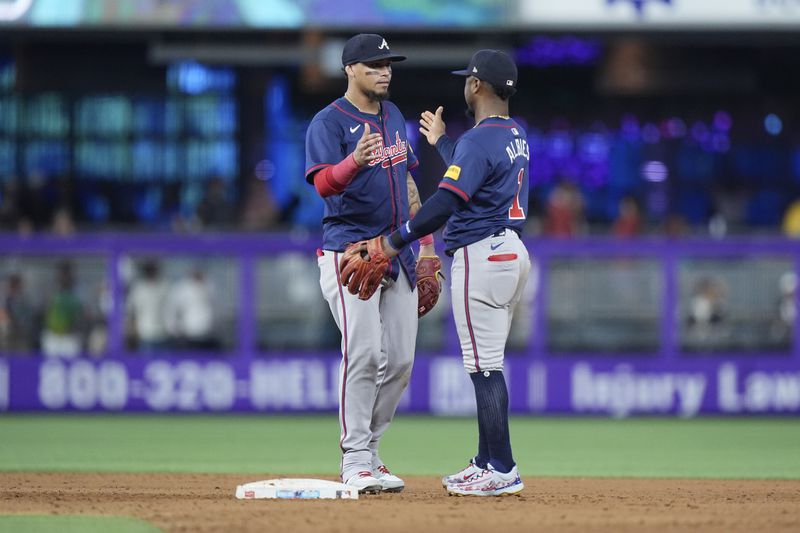 Atlanta Braves shortstop Orlando Arcia, left, and second baseman Ozzi Albies (1) congratulate each other after the Braves beat the Miami Marlins 5-4, during a baseball game, Sunday, Sept. 22, 2024, in Miami. (AP Photo/Wilfredo Lee)