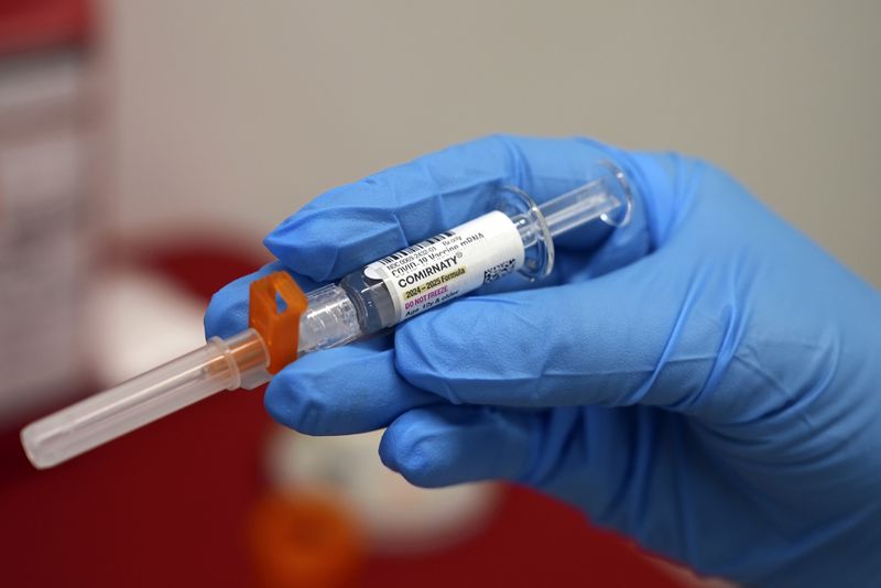 A pharmacist holds a COVID-19 vaccine at a pharmacy in New York, on Tuesday, Sept. 24, 2024. (AP Photo/Mary Conlon)