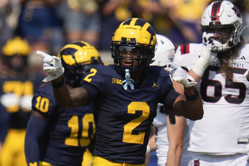 Michigan defensive back Will Johnson (2) celebrates sacking Arkansas State quarterback Jaylen Raynor in the first half of an NCAA college football game in Ann Arbor, Mich., Saturday, Sept. 14, 2024. (AP Photo/Paul Sancya)