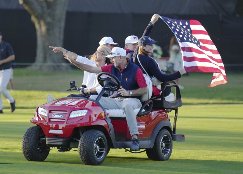 United States team captain Jim Furyk, center front, drives down the 18th fairway after winning the Presidents Cup golf tournament at Royal Montreal Golf Club Sunday, Sept. 29, 2024, in Montreal. (Nathan Denette/The Canadian Press via AP)