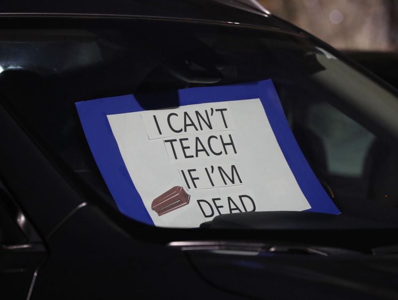 012121 Marietta: A teacher places a sign in her car while hundreds of Cobb County teachers and staff hold a protest in the parking lot during the school board meeting at the Cobb County School District's Offices on Thursday, Jan. 21, 2021, in Marietta. Cobb teachers are pressing the district for improved COVID-19 response.  Curtis Compton / Curtis.Compton@ajc.com”