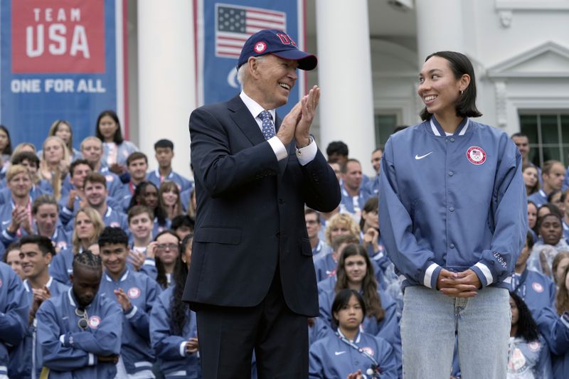 President Joe Biden, left, and Olympic swimmer Torri Huske attend an event celebrating the 2024 U.S. Olympic and Paralympic teams on the South Lawn of the White House in Washington, Monday, Sept. 30, 2024. (AP Photo/Susan Walsh)